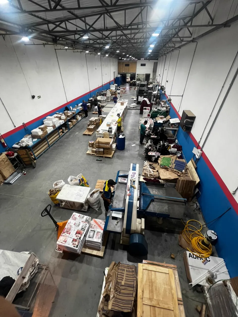 Vista geral da produção, com máquinas e equipe em ação